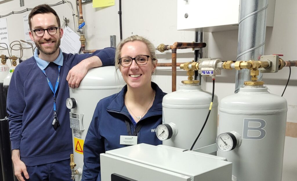 An Image of two members of the Willows team standing next to a new Atlas Copco oxygen generator